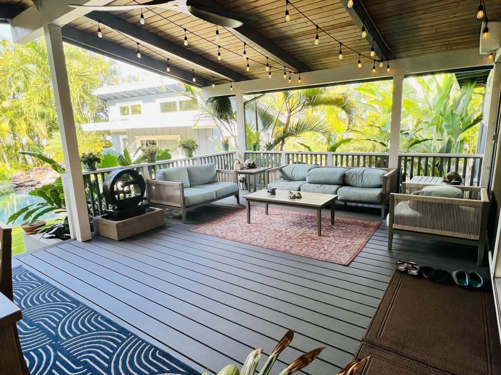 Stylish Trex Transcend Island Mist deck boards with a picture frame border, set against a lush tropical backdrop in Kailua, Oahu. The photo highlights the inviting outdoor space with a subtle view of the pool, blending modern design and island living.