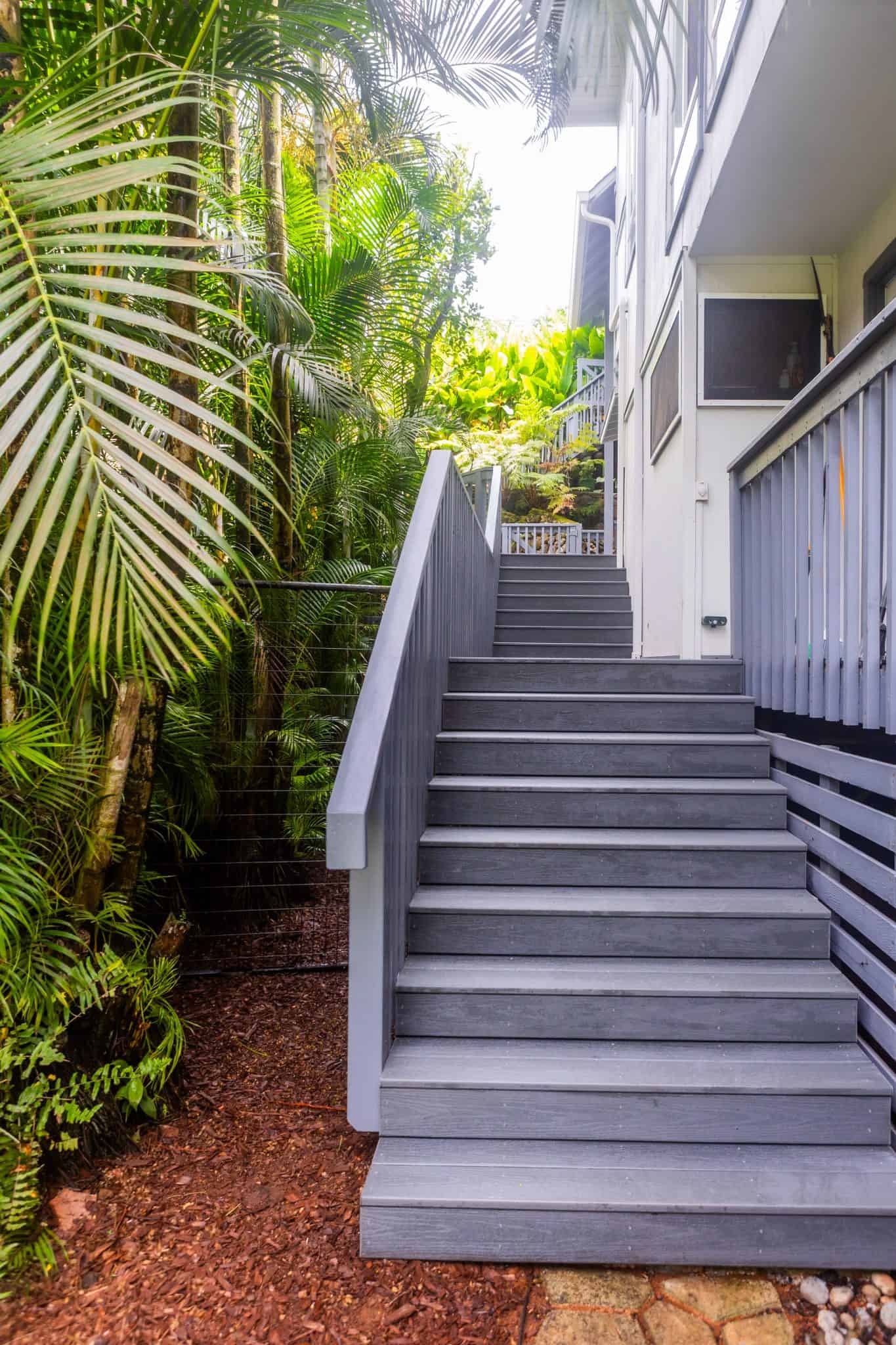 Trex Clam Shell deck stairs in Kahaluu, Oahu, built with color-matched screws and a new substructure, surrounded by lush tropical greenery.