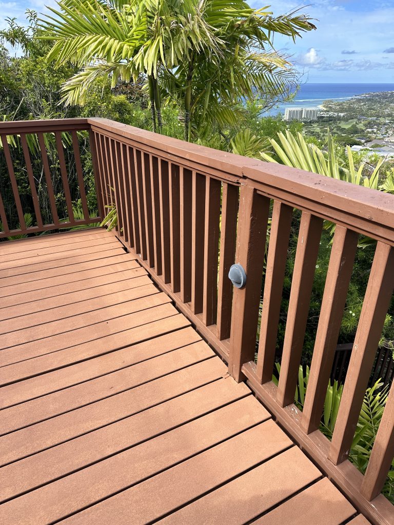 Before photo of Waialae Iki deck showing worn composite deck boards and outdated railing prior to remodel.